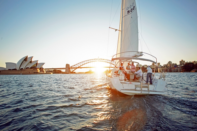 A group of people on a yacht sailing on Sydney Harbour, with the Sydney Harbour Bridge and Sydney Opera House in the background © Tourism Australia